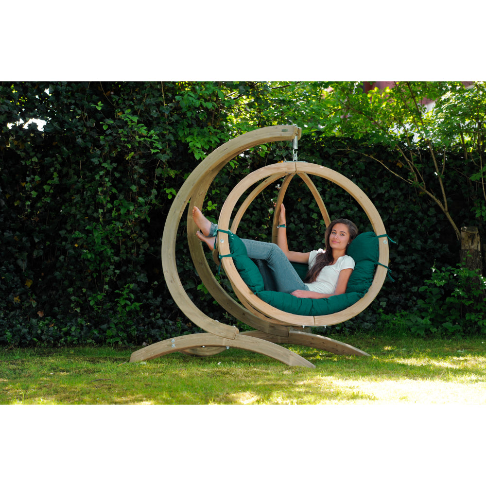 Women relaxing in green egg nest chair