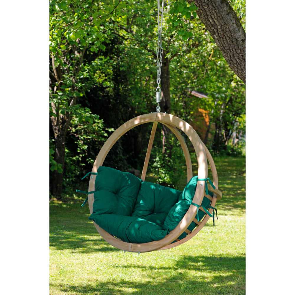 Hanging basket chair hanging from a tree in garden